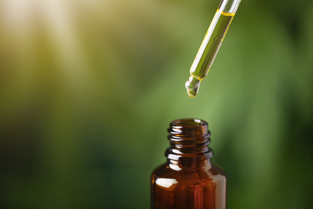 CBD hemp oil on cannabis leaf background. CBD oil extract. Medical cannabis sativa extraction. Biomedical and hemp herbal medicine.の写真素材
