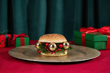 Creative Christmas hamburger and Christmas prrsents on table. Creative New Year or Christmas food concept. Burger made from fir branches and  ornaments.の写真素材