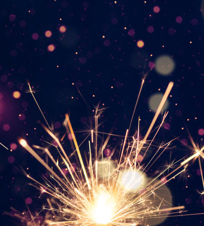 Burning sparkler with  bokeh light on blue background. New year party background. New year sparkles.の写真素材