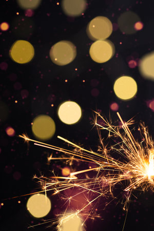 Burning sparkler with golden bokeh light background. New year party background. New year sparkles.の写真素材