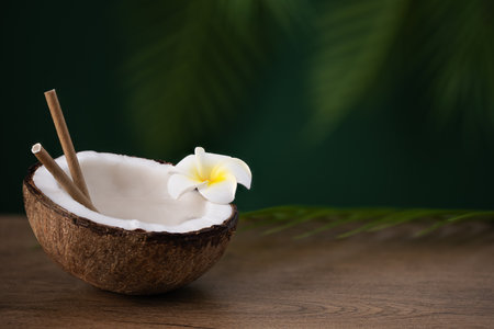 Half of coconut with coconut water on wooden table. Tropical summer healthy coconut cocktail.の写真素材