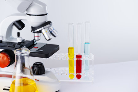 Microscope and laboratory glassware containing chemical liquid for research and analysing. Laboratory equipment for research and student study.の写真素材
