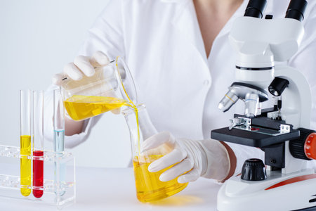 Scientist researching in laboratory with hemp CBD oil. Woman working in laboratory with oil extract...