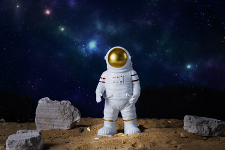 Figurine of astronaut over blue star sky background, copy space. Toy of spaceman. Space and space flights concept. Day of cosmonauts.の写真素材