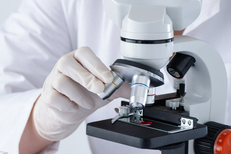 A person is using a microscope in medical laboratory to examine blood. DNA blood test.