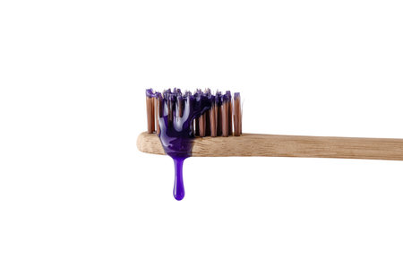 Swatch of whitening purple toothpaste on wooden toothbrush isolated on white background. Texture of purple tooth gel for whitening teeth, plastic free concept.の写真素材