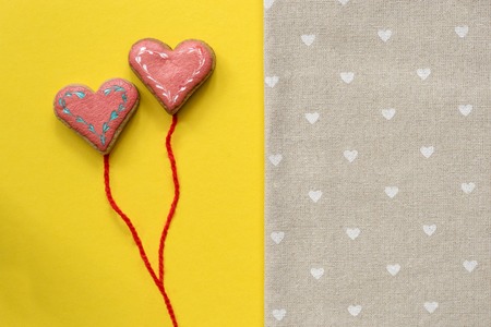 Heart shaped sugar cookies on yellow background. Valentines day card concept.