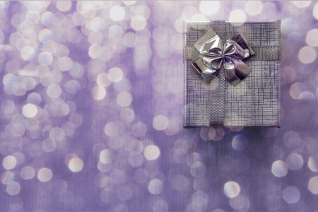 Gift box over violet bokeh background. Closeup. Copy spaceの写真素材