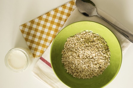 A close-up top view of oatmeal with yoghurt on white table. Healthy breakfast.の写真素材
