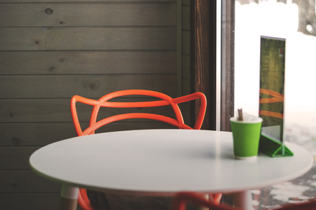 Orange modern chair and white table in cozy comfortable cafeの写真素材