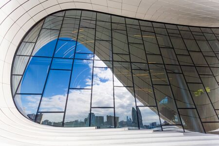 Baku, Azerbaijan, Novemver 07.2016: Close-up view of the Heydar Aliyev Center designed by architect Zaha Hadid. Sunny weather, blue sky and reflections in windowsのeditorial素材