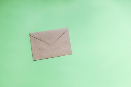 Kraft paper envelopes on a green background. Perfect for invitations, card, message decorationsの写真素材