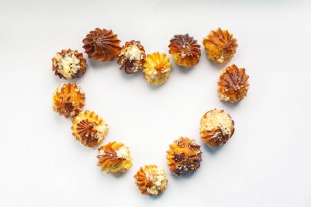 Heart made of profiteroles. Romantic food frame on a white background. Homemade baking. Dessert...