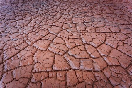 Red cracked ground background. Salt dry polluted soil. Global warming and climate change....