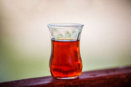 A Glass of turkish tea close-up. Traditional Turkish drink. Strongly brewed tea in a transparent cup on the tableの写真素材