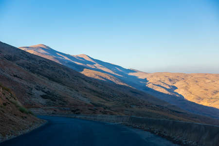 Asphalt serpentine road in the mountains of Lebanon, in the Kadisha Valley. A turn in the road on a mountain track. Beautiful hills in the sunlight. Middle Eastern Lebanese landscapeの写真素材
