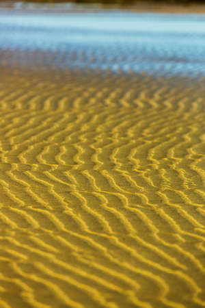 Sand patterns. Abstract natural background. Sand ripples and waves. Sunny sea view. Ocean beach. Moody landscape. Tourist resortの写真素材