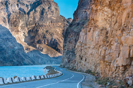 The confluence of the Avar koysu and the Andi koysu into the Sulak river. Blue water of the Sulak river among the rocks. Asphalt road in the mountains in Dagestan, Russiaの写真素材
