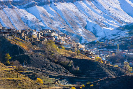 Chokh village close up, Dagestan, Russia. Panoramic view of the village Chokh on the backdrop of snowy mountains. Historic houses and streets on slopesの写真素材