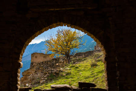 Ruins and towers of the abandoned village of Goor, Dagestan, Russia. View through the window of the...