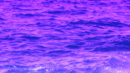Sea water texture. Deep violet abstract background. Purple waves surfaceの写真素材