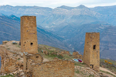 Towers of the abandoned village of Goor, Dagestan, Russia. Stone towers on the rocks and blue sky on the background. Panoramic view of the Caucasus Mountainsの写真素材