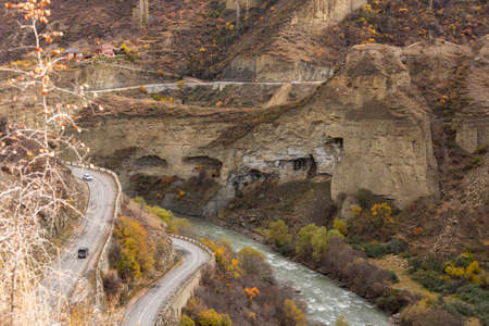 Serpentine road to the village of Gunib, Dagestan, Russia. A sharp turn in the road. Beautiful highway in autumn in the mountains. Orange landscapeの写真素材
