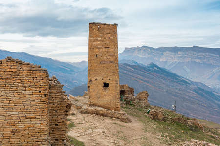 Tower of the abandoned village of Goor, Dagestan, Russia. Stone tower on the rocks and blue sky on the backgroundの写真素材