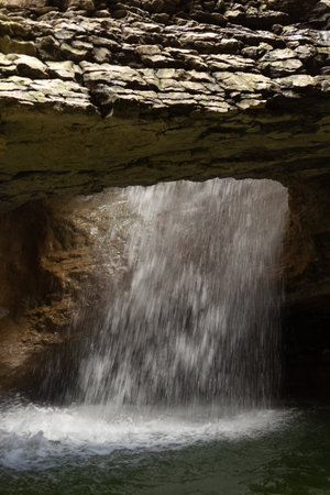 Saltinsky waterfall in Salta, Dagestan, Russia. Turbulent water flow in motion. Underground cascade. Jets of water fall into the lakeの写真素材