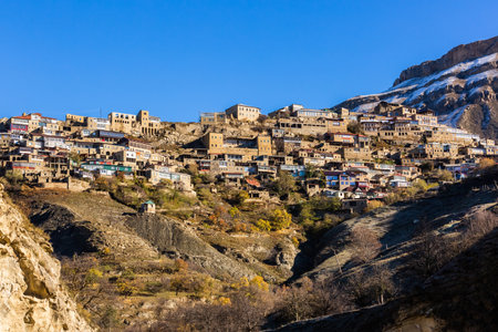 Chokh village close up, Dagestan, Russia. Panoramic view of the village Chokh on the backdrop of snowy mountains. Historic houses and streets on slopesの写真素材
