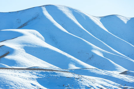 Beautiful panoramic view of snow capped mountains, Dagestan, Russia. beautiful winter landscape. Snowy hills in sunlight. Minimalist mountain sceneの写真素材