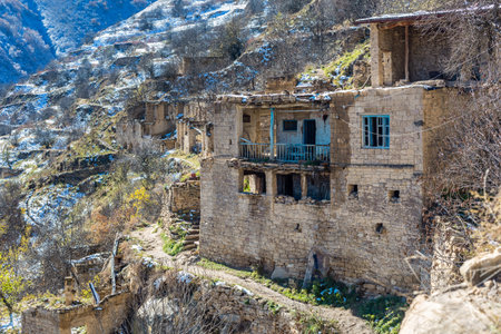 Abandoned ghost town of Gamsutl, Dagestan, Russia. Old houses on the backdrop of snow-capped mountains. Historic quarter at the top of the mountainの写真素材