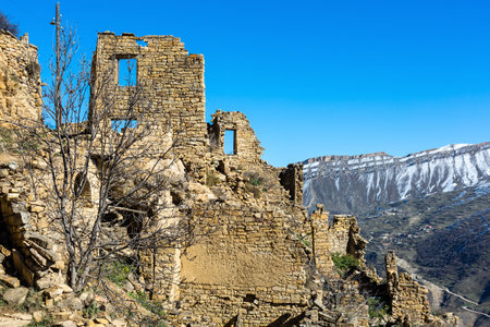 Abandoned ghost town of Gamsutl, Dagestan, Russia. Old houses on the backdrop of snow-capped mountains. Historic quarter at the top of the mountainの写真素材