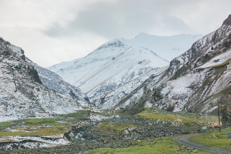 Panoramic view of the dirt road among the mountains of Dagestan, Russia. Autumn landscape and highway. Mountain road among the rocksの写真素材
