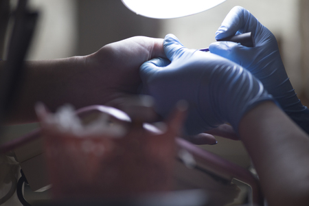 The girl on the manicure. The master covers the nail gel polish. Cosmetic proceduresの写真素材