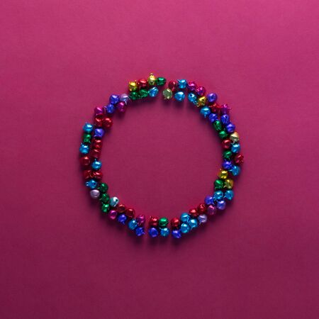 Colourful jingle bells frame on red background.の写真素材