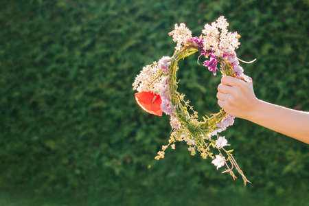 Woman holding flower wreath. Summer solstice day. Midsummer.の写真素材