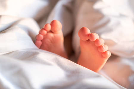 Childrens feet peeking out from under the blanket.