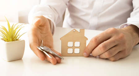 Hand holding three keys over the hand on sunset background, Building conceptの写真素材