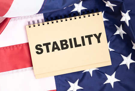 STABILITY. TEXT ON A WHITE BACKGROUND ON THE AMERICAN FLAG. BUSINESS CONCEPTの写真素材