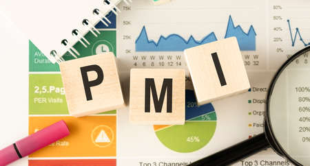Text PMI on wood cube and gold pen lay on chart candle document paper, economic data concept.