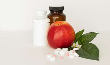 Bottle with weight loss pills and apple on white backgroundの写真素材