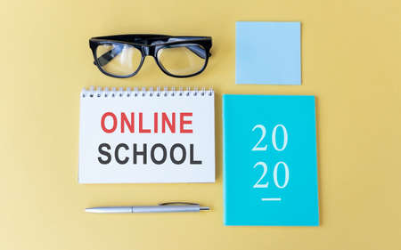 Online School inscription, glasses, notebook and pen on a yellow background. Background, copy space, top view, flat lay.の写真素材