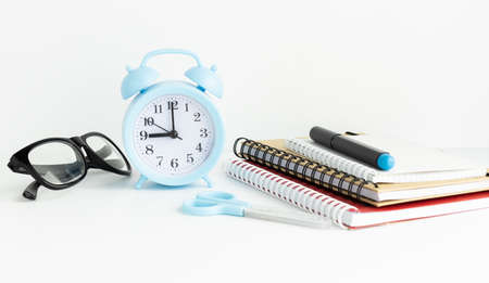 Time to school and education concept. Books with pencil holder on white table. Blackboard in background.の写真素材
