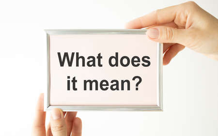 Text What Does It Means question. Concept meaning asking someone about meaning you do not understand Man holds empty paper with copy space in front of him Copy Space.の写真素材