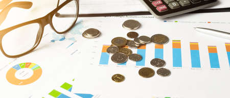 Colorful sales charts, calculator, blue pen and glasses. Shallow DOF, focus on chartsの写真素材