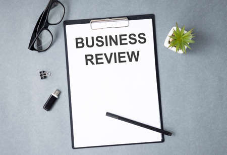 Card with time for Business Review text message isolated on gray wall office background.の写真素材