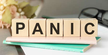 Word panic on wooden cubes with reflection on white glossy backgroundの写真素材