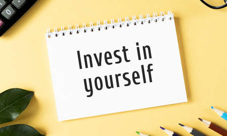 Invest in yourself text written in a notebook. View from aboveの写真素材