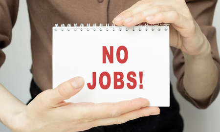 No Jobs, inscription, phrase written in a notebook that lies on a dark table with a pen. Business concept.の写真素材